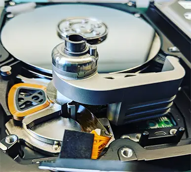 Inside an opened hard drive showing platters and head assembly in cleanroom